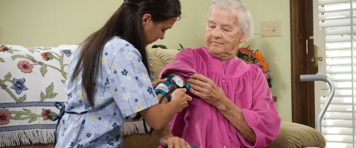 An older adult checking blood pressure at home.