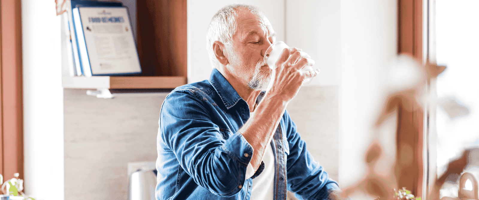 An older adult drinking water to prevent dehydration.