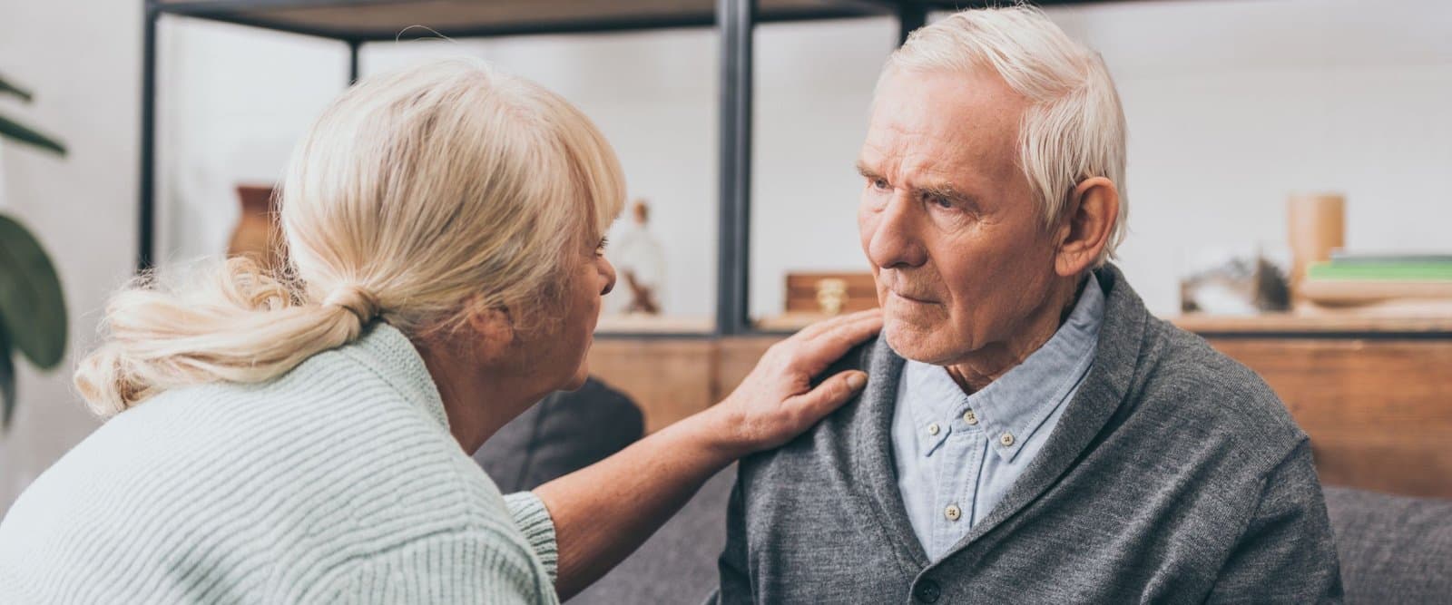 A caregiver calmly supporting an older adult at bedtime.